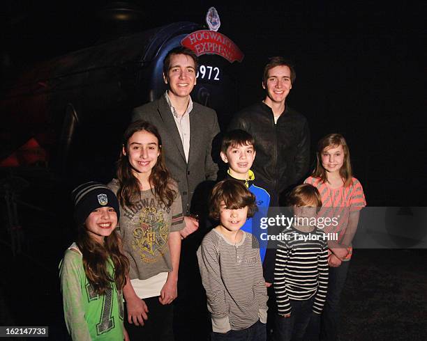 Twin actors Oliver Phelps and Jamie Phelps pose in front of the Hogwarts Express at Harry Potter:The Exhibition at Discovery Times Square on February...