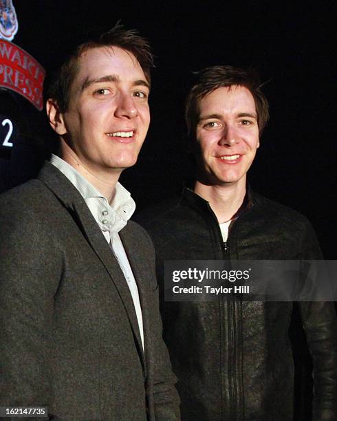 Twin actors Oliver Phelps and Jamie Phelps pose in front of the Hogwarts Express at Harry Potter:The Exhibition at Discovery Times Square on February...