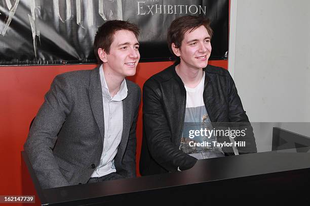Twin actors Oliver Phelps and Jamie Phelps pose together at Harry Potter: The Exhibition at Discovery Times Square on February 19, 2013 in New York...