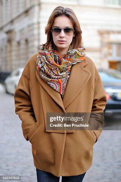 Model Alesandia poses wearing a Celine coat, Ray Ban glasses with a vintage scarf at Somerset House during London Fashion Week on February 19, 2013...