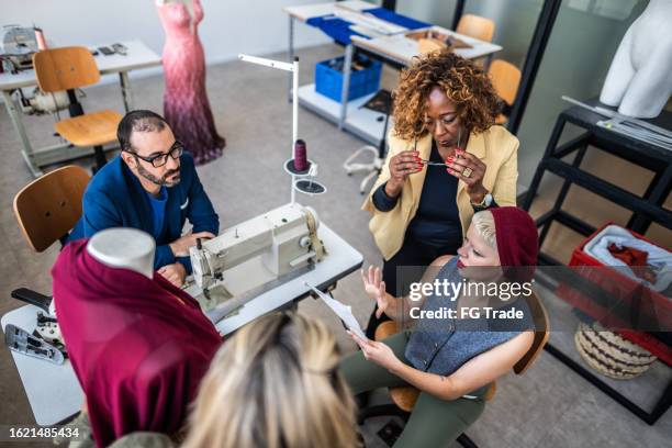 tailors working on a meeting in studio atelier - mode ontwerper stockfoto's en -beelden