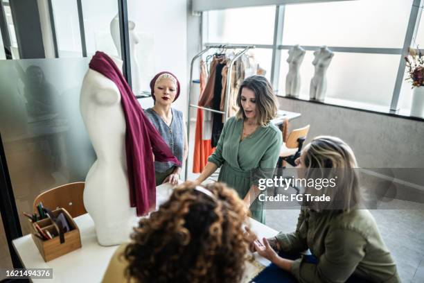 tailors working on a meeting in studio atelier - fashion designer mannequin stock pictures, royalty-free photos & images