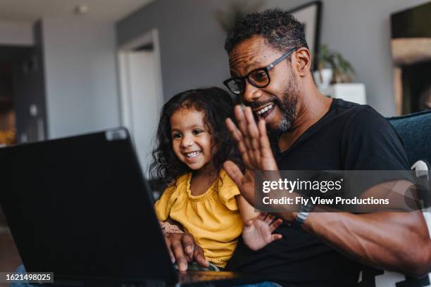 a father and daughter use video chat on a laptop computer - oskuldsfullhet bildbanksfoton och bilder