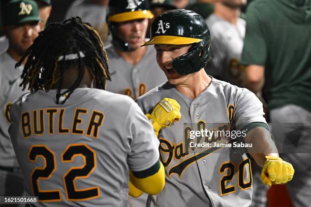 Zack Gelof of the Oakland Athletics celebrates his two-run home run in the dugout with Lawrence Butler during the seventh inning against the Chicago...