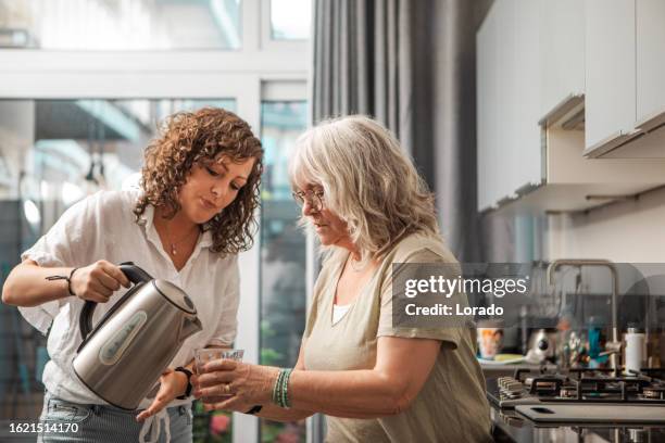 everyday lifestyle of a 75 year old senior woman and daughter - 39 year old stockfoto's en -beelden