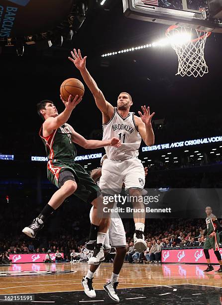 Ersan Ilyasova of the Milwaukee Bucks scores two in the first half as Brook Lopez of the Brooklyn Nets defends at the Barclays Center on February 19,...