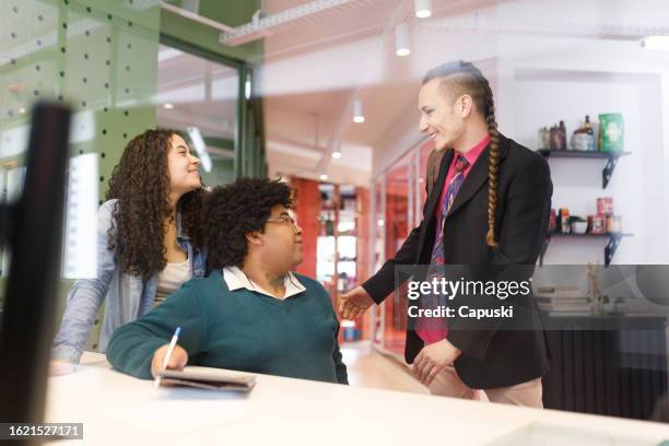 man talking to his team after arriving at the office - publicidade stock pictures, royalty-free photos & images