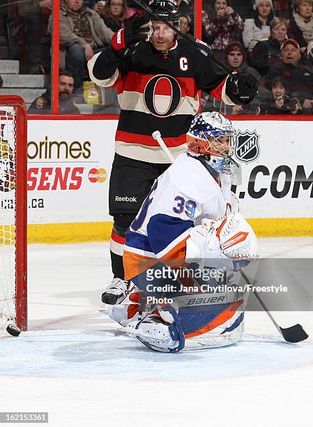 Daniel Alfredsson of the Ottawa Senators celebrates a second period goal as Rick DiPietro of the New York Islanders looks on, during an NHL game at...