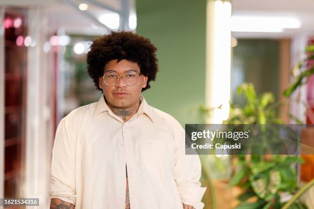 curly haired woman wearing glasses in the office - publicidade stock pictures, royalty-free photos & images