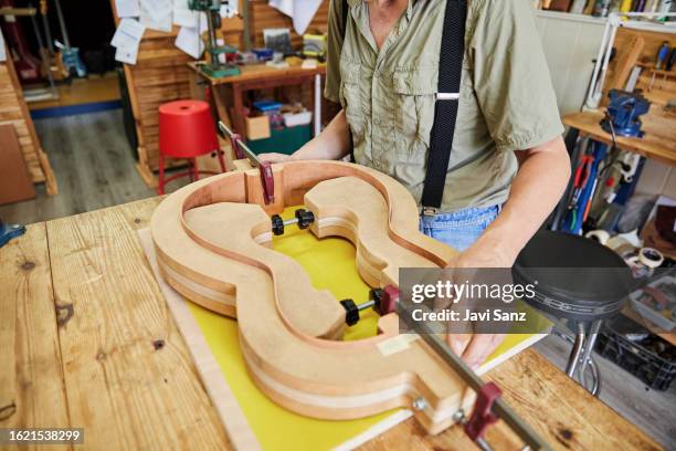 unrecognizable luthier building an acoustic guitar in his craftsman's studio - musical instrument repair stock pictures, royalty-free photos & images