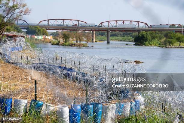 The edge of the Rio Grande in Eagle Pass' Shelby Park is lined with concertina wire in Eagle Pass, Texas on August 24, 2023. The buoys were installed...