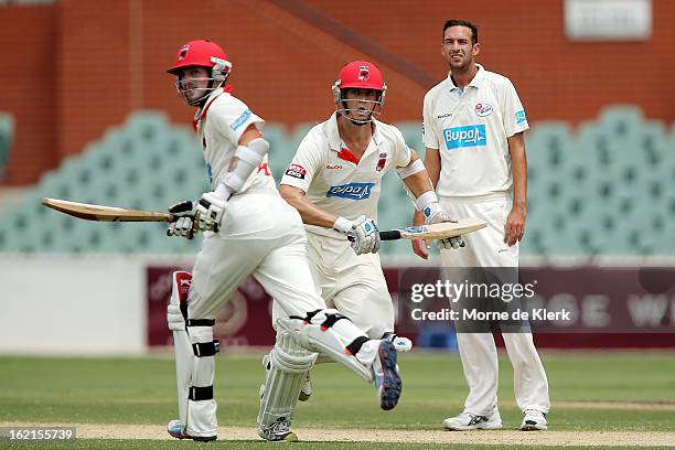 Trent Copeland of the Blues looks on as Chadd Sayers and Joe Mennie of the Redbacks gets runs during day two of the Sheffield Shield match between...