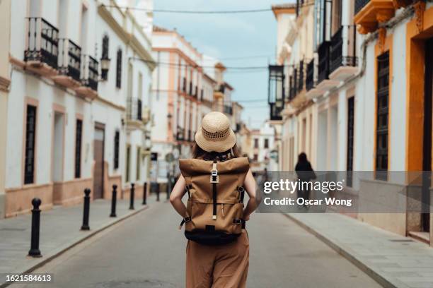 rear view of young asian female backpacker exploring the street - europe travel stock-fotos und bilder