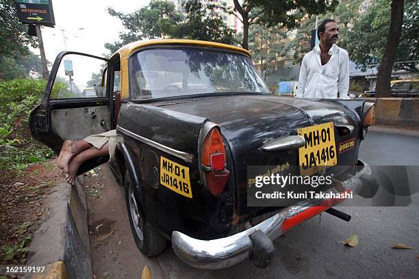Driver sleeps in the back seat of Premier Padmini taxi on December 7, 2012 in Mumbai, India. The Padmini, manufactured by Premier Automobiles in...