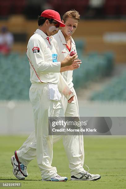 Tom Cooper and Joe Mennie of the Redbacks look at the ball during day two of the Sheffield Shield match between the South Australian Redbacks and the...
