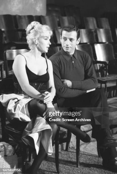Marilyn Monroe chatting with Yves Montand between filming the 1960 comedy 'Let's Make Love'.