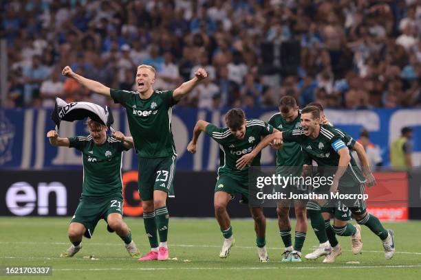 Panathinaikos FC players celebrate as team mate Filip Mladenovic scores the decisive penalty in the shoot out following the UEFA Champions League...