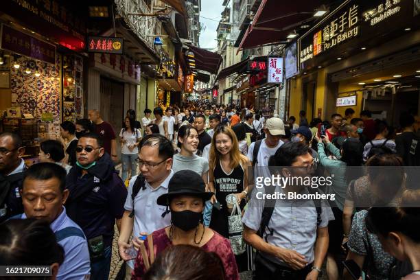 Pedestrians past stores in Macau, China, on Thursday, Aug. 24, 2023. Macau's economy continued to recover, driven by the tourism and gaming sectors,...