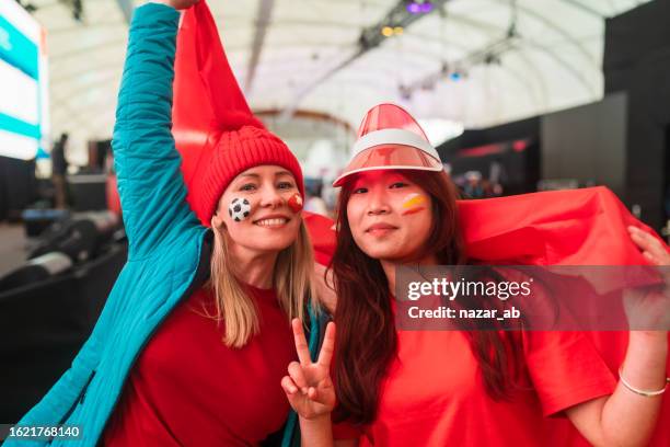 soccer supporters holding national flag, woman makes victory sign. - new zealand stadium stock pictures, royalty-free photos & images