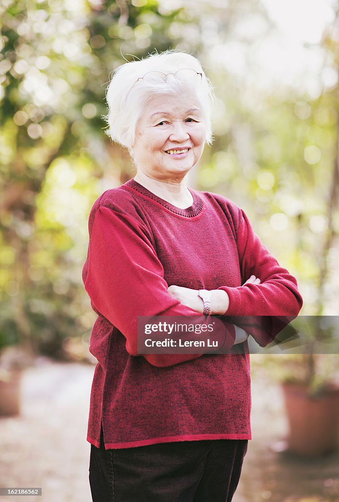 Senior woman stands in the garden