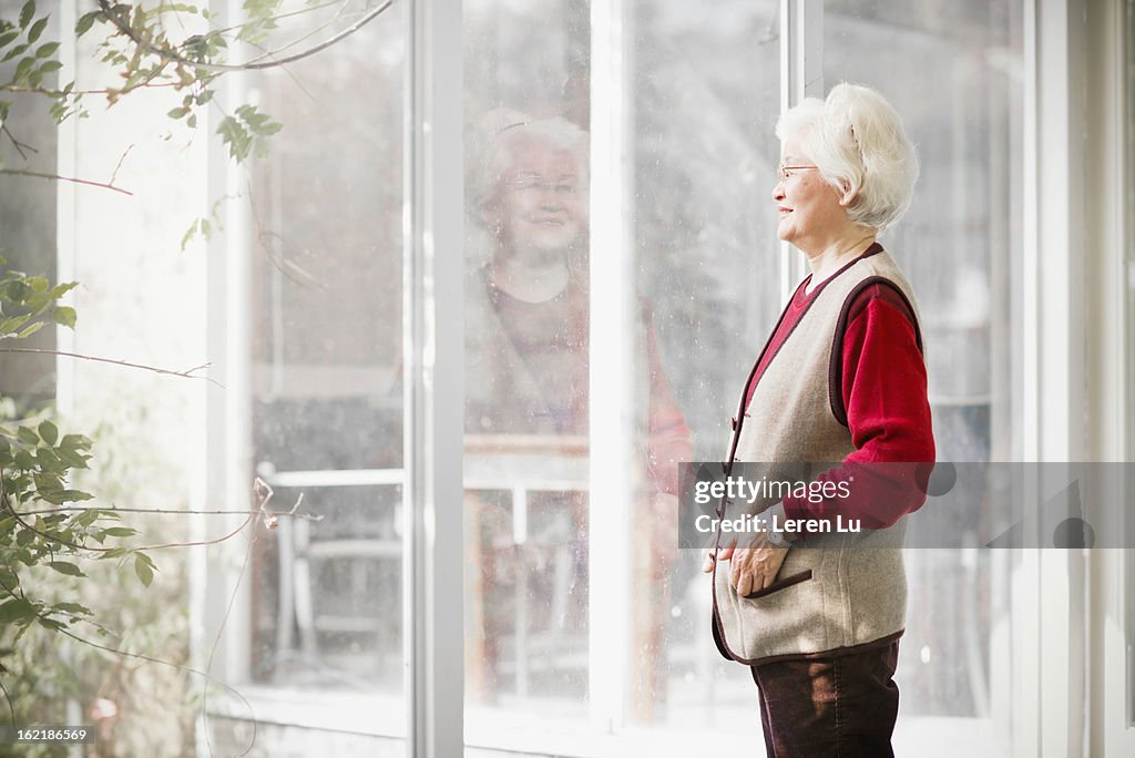 Senior woman looks through view window