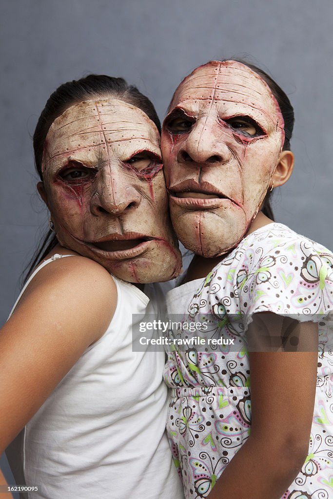 Two mexican girls wearing bizarre masks.