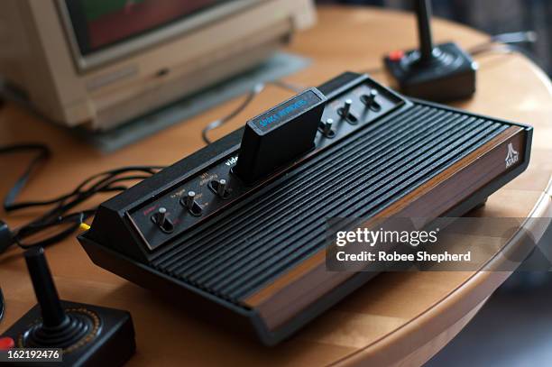 Atari 2600 VCS console, full view, with joysticks and Commodore 1084S monitor partially visible. 1978 six switch model. Space Invaders game is...