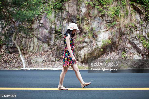 young girl walking straight the yellow line on the - dubbla gula linjer bildbanksfoton och bilder