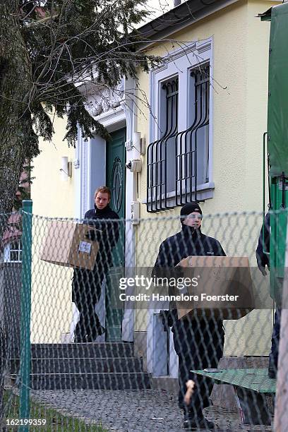 Policemen carry boxes out of the headquarters of the S&K investment group the day after police raided the company's offices on February 20, 2013 in...