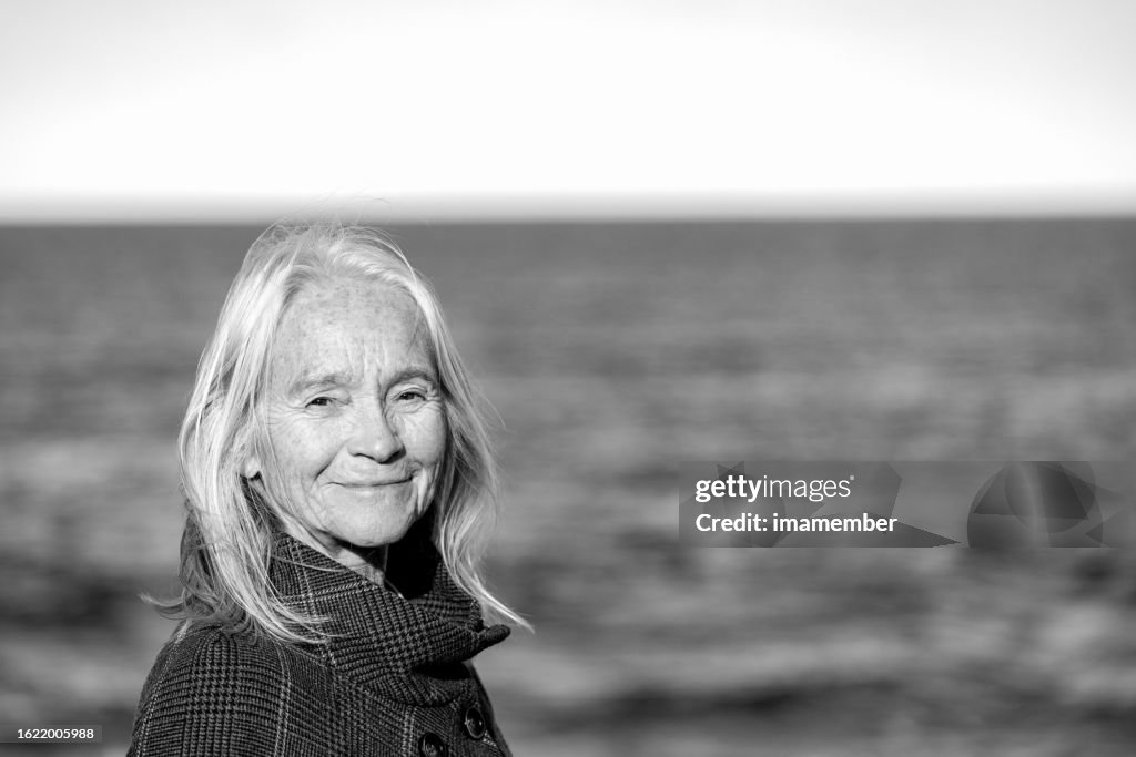 Black and white potrait of happy senior woman outdoor, background with copy space
