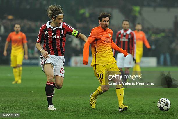 Massimo Ambrosini of AC Milan competes with Lionel Messi of Barcelona during the UEFA Champions League Round of 16 first leg match between AC Milan...