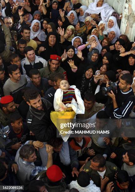 Palestinians carry the body of Rima Assamna, one-year-old, during her funeral procession in the northern Gaza Strip town of Beit Hanun 09 November...