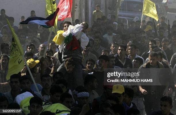 Palestinian man carries the body of one of two babies killed during the mass funeral of 18 people in the northern Gaza Strip town of Beit Hanun 09...