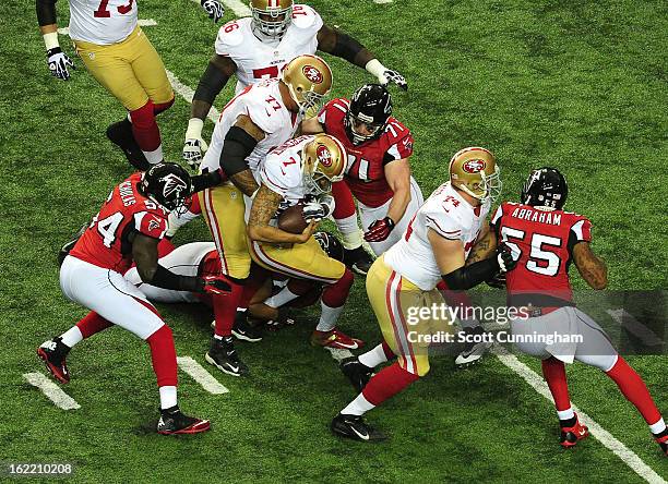 Quarterback Colin Kaepernick of the San Francisco 49ers is tackled by Kroy Biermann and Stephen Nicholas of the Atlanta Falcons during the NFC...