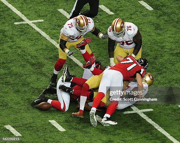 Quarterback Colin Kaepernick of the San Francisco 49ers is tackled by Kroy Biermann and Stephen Nicholas of the Atlanta Falcons during the NFC...