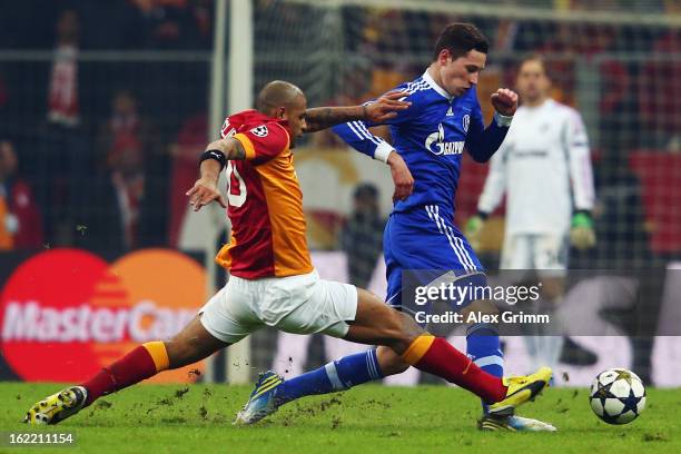 Julian Draxler of Schalke is challenged by Felipe Melo of Galatasaray during the UEFA Champions League Round of 16 first leg match between...