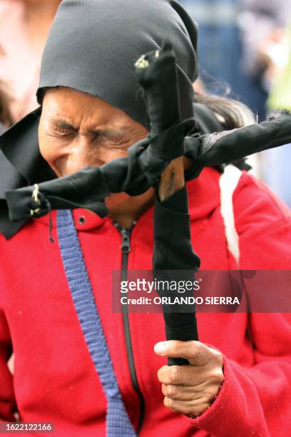 Una mujer sostiene un cruz, durante una manifestación de familiares y víctimas del conflicto armado interno para exigir al gobierno del presidente...
