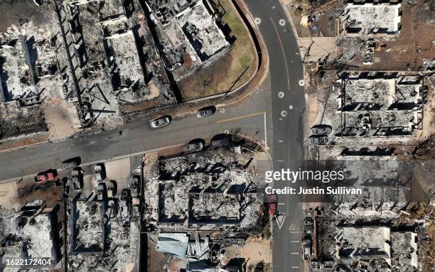 In an aerial view, burned cars and homes are seen a neighborhood that was destroyed by a wildfire on August 17, 2023 in Lahaina, Hawaii. At least 111...