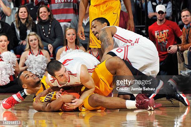 Julian Welch of the Minnesota Golden Gophers and Aaron Craft of the Ohio State Buckeyes battle for a loose ball in the second half as Lenzelle Smith...