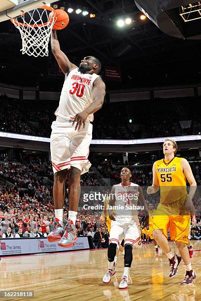 Evan Ravenel of the Ohio State Buckeyes slam dunks the ball after making a steal in the second half as Elliott Eliason of the Minnesota Golden...
