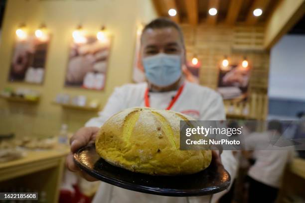 Chef poses holding a rustic bread where vendors of bakery and pastry tools offer their products during the Expo Pan at the World Trade Center in...