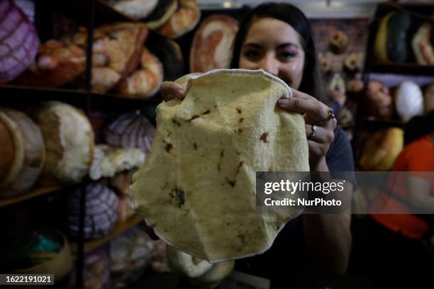 Woman holds a pillow with a flour tortilla figure where vendors of bakery and pastry tools offer their products during the Expo Pan at the World...