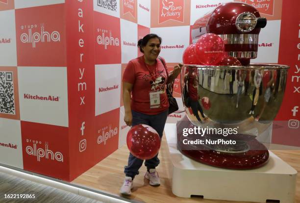 Woman is photographed with a scale mixer where vendors of bakery and pastry tools offer their products during the Expo Pan at the World Trade Center...