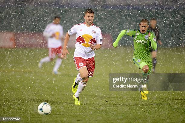 Tyler Ruthven of the New York Red Bulls and David Estrada of the Seattle Sounders chase after the ball at Kino Sports Complex on February 20, 2013 in...