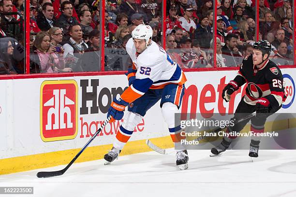 Chris Neil of the Ottawa Senators skates after a puck carrying Joe Finley of the New York Islanders during an NHL game at Scotiabank Place on...