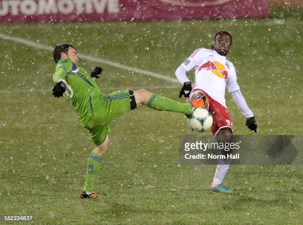 Peguy Luyindula of the New York Red Bulls battles for the ball with Zach Scott of the Seattle Sounders at Kino Sports Complex on February 20, 2013 in...