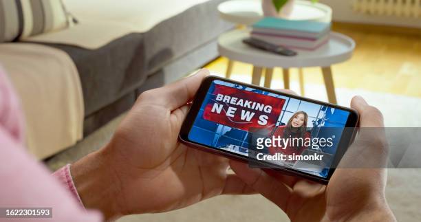 man watching news on smart phone - breaking news stock pictures, royalty-free photos & images