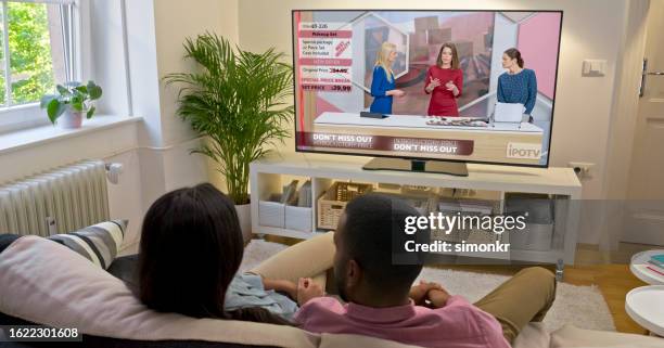 couple watching tv at home - television advertisement stock pictures, royalty-free photos & images