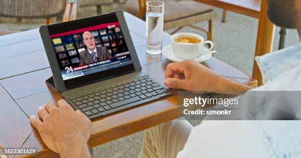 mann mit tablet im straßencafé - breaking news stock-fotos und bilder