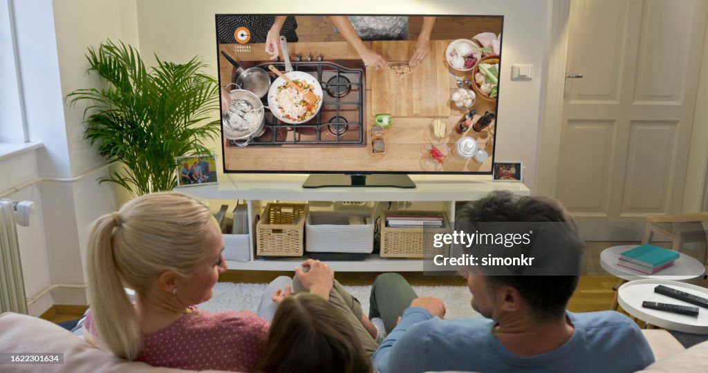 Family watching TV at home